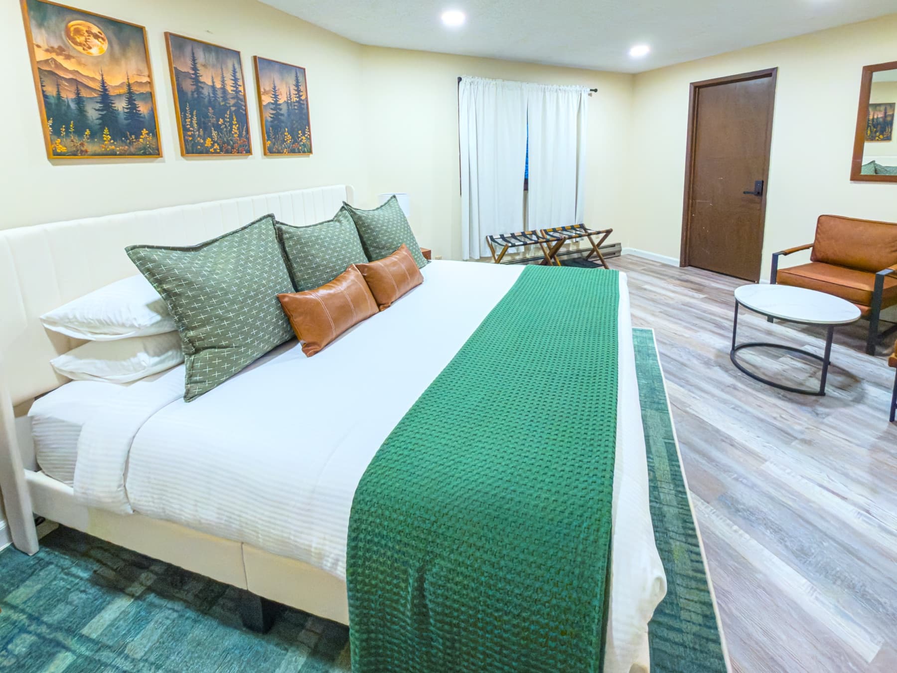 Upstairs king suite — bed, sitting area, bright windows